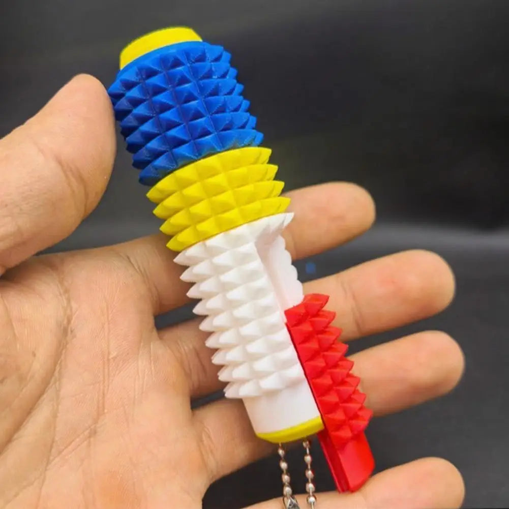 Un colorido rodillo giratorio para fidget con pinchos antiestrés 5 en 1, con secciones segmentadas de pinchos de plástico en azul, amarillo, blanco y rojo, diseñado para un alivio eficaz del estrés.