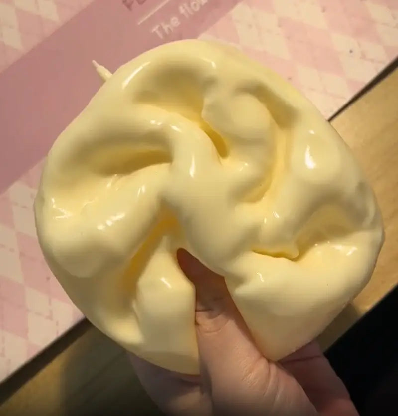 un jouet à mâcher et à malaxer en forme de fromage jaune pâle, brillant, conçu pour soulager le stress, de texture souple et malléable, conçu pour apaiser le stress lié au jouet et pour une utilisation de soulagement du stress