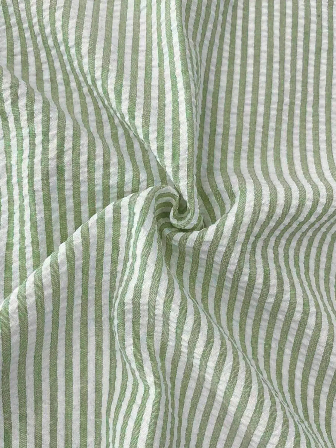 Chemise décontractée boutonnée manches longues à rayures bleues pour homme, fabriquée dans un coton à rayures verticales vert clair et blanc, avec un tissage texturé discret.