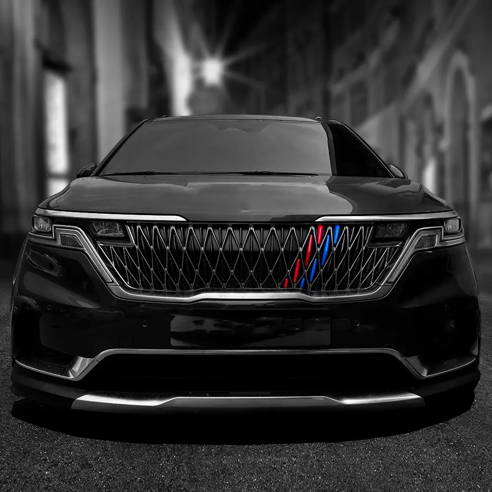 Schwarzer SUV mit verchromtem Kühlergrill, der rote, blaue und silberne Akzente mit M-Branding aufweist, in einem Kia Carnival Ka4 Frontgrill-Zierleisten-ABS für die Jahre 2022–2024.