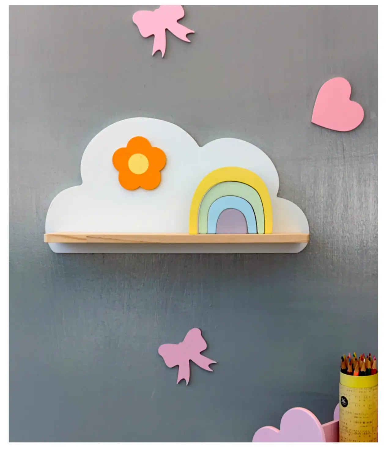 Buntes Regenbogen-Wolken-Bücherregal aus Holz für Kinder an der Wand mit einer weißen, wolkenförmigen Ablage, Holzsockel, einer orangefarbenen Blume und einem Regenbogendesign.