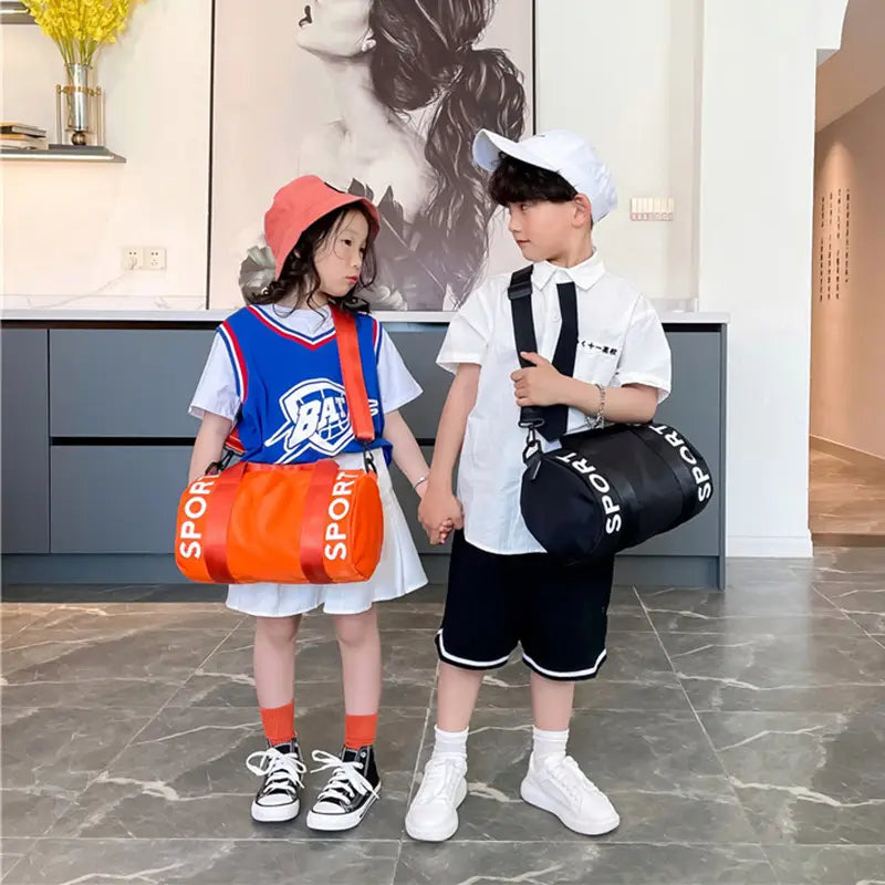 Orange-schwarze Kinder-Sport-Reise-Sporttasche mit kräftigem Sport-Branding, ideal für Reise-, Gym- und Crossbody-Gepäck.