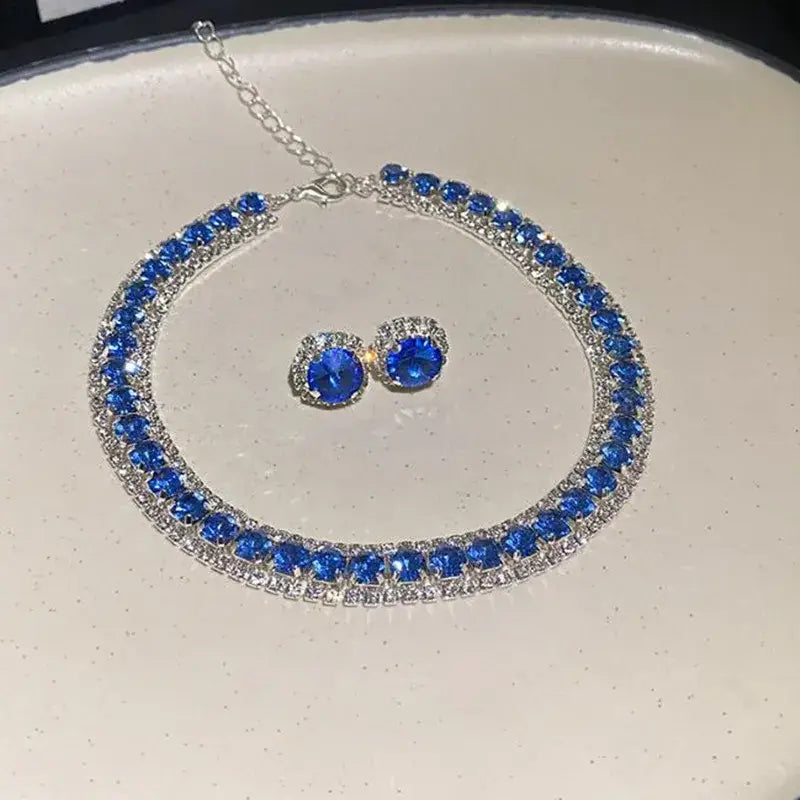 a crystal necklace and earring set featuring a sparkling blue and silver rhinestone choker with a double row of vibrant sapphire blue stones set in a metallic frame for pink ab wedding jewelry