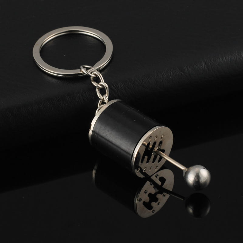 Black and silver manual gear shift car keychain made of metal with a metallic ball end.