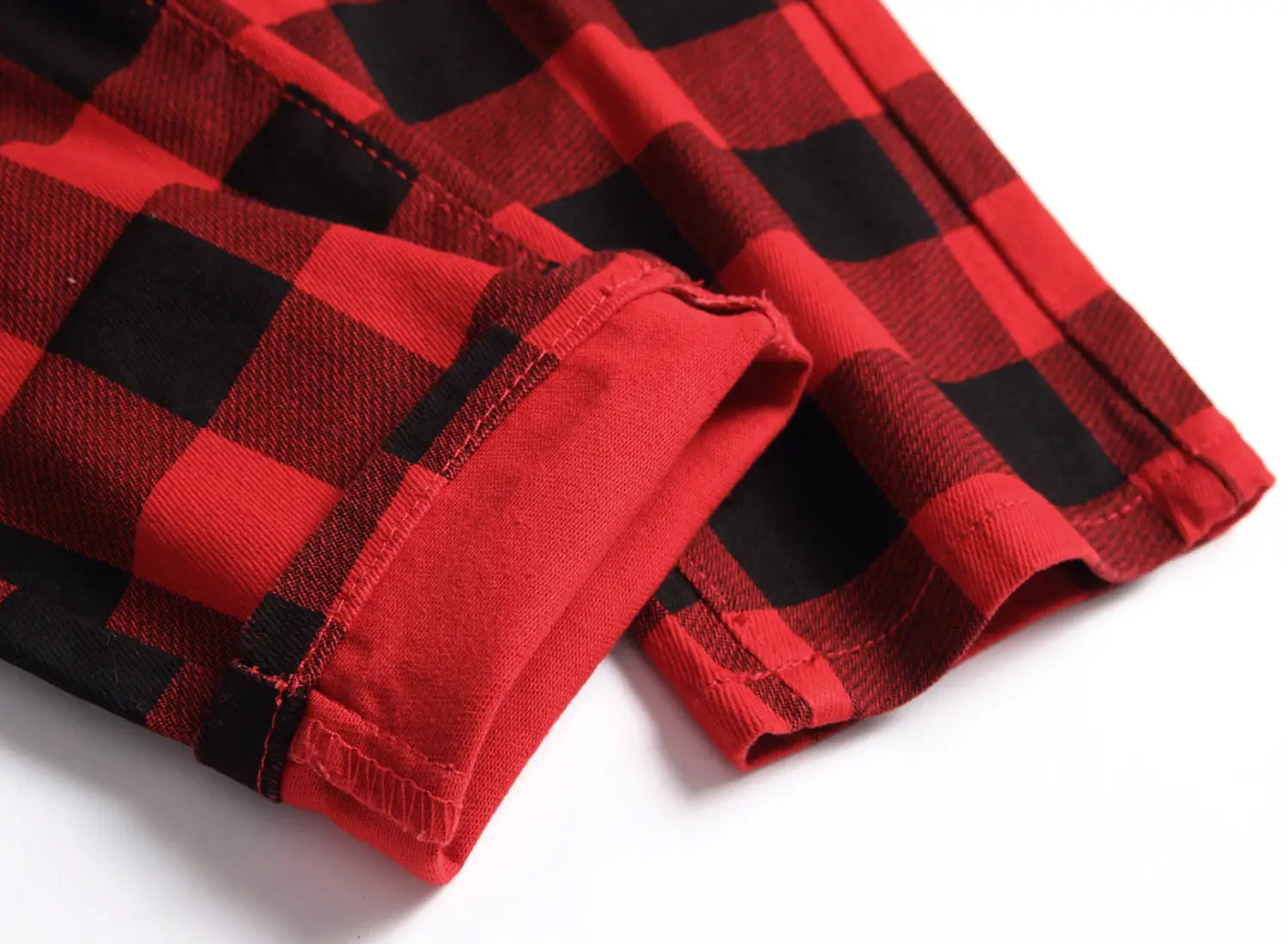 Jeans en denim rouges à carreaux, coupe slim ajustée, présentant un motif classique à carreaux en coton rouge et noir.