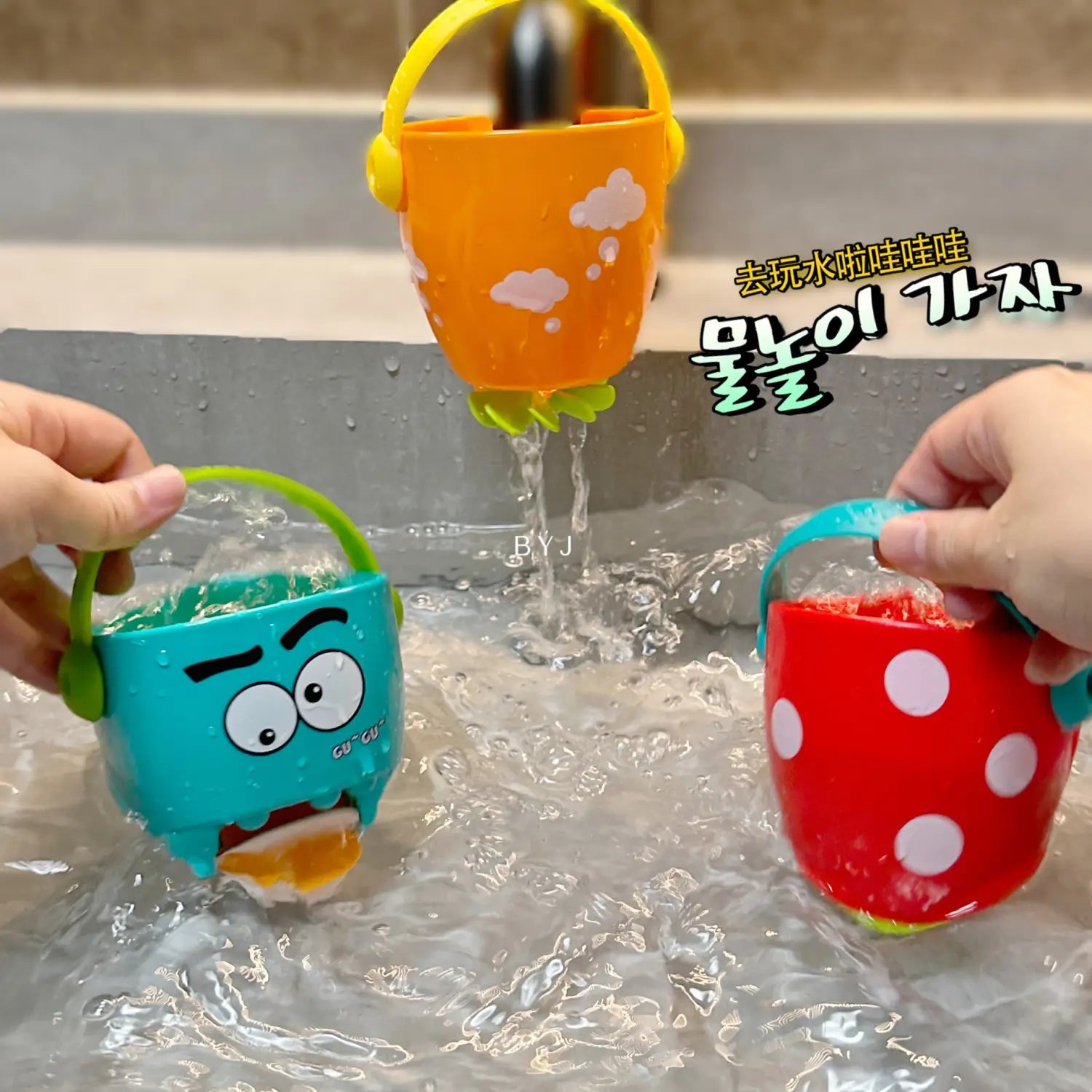 Orange, teal und rote Kunststoff-Badewannen-Eimer für Babys mit Cartoon-Gesichtern und Punkten; mit gelb-grünen Griffen für ein Wassersprühspielset.