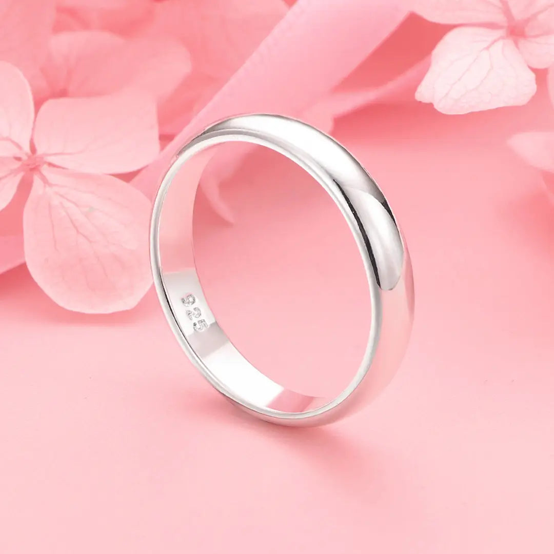 A sleek polished silver band ring 925 sterling with a smooth rounded profile and subtle inner engraving.