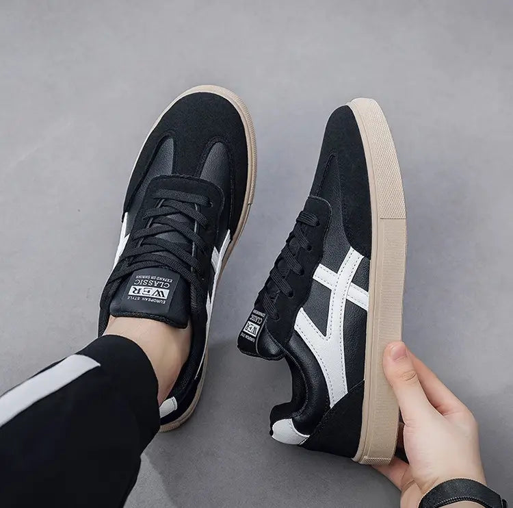Sneakers décontractées pour hommes, chaussures de marche légères, en daim noir et blanc au design classique, semelle extérieure en caoutchouc beige et logo Onitsuka Tiger sur la languette.