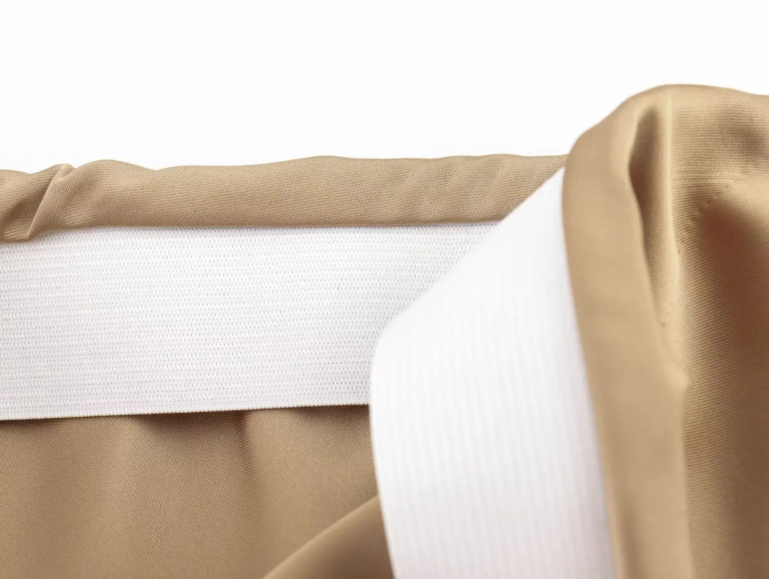 Tissu en satin taupe avec une bande élastique blanche cousue le long de l’ourlet d’une jupe midi en satin à taille haute, longue et élégante