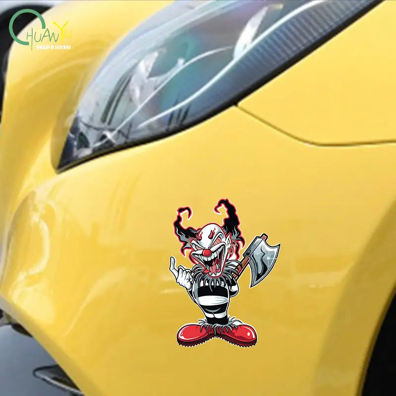 Un autocollant de voiture de clown maléfique de dessin animé vibrant : autocollant imperméable avec des cheveux rouge et noir, un visage blanc, une tenue rayée, des chaussures rouges et tenant une hache.