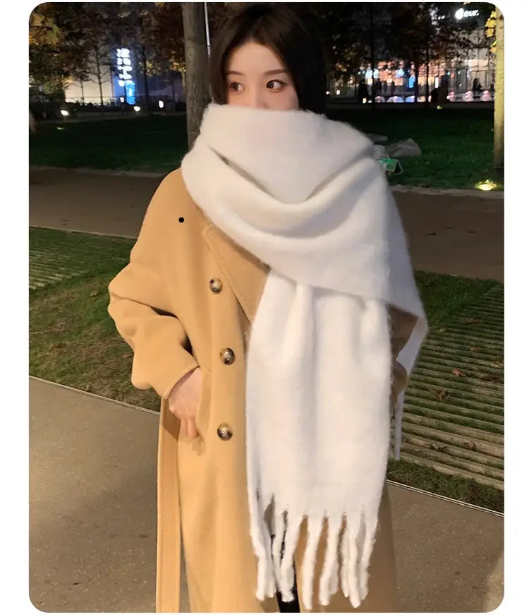Una bufanda tejida blanca esponjosa con bordes suaves con flecos, presentada como bufanda de cachemir de invierno rosa para mujer.