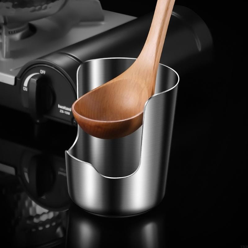 A stainless steel pot lid and spoon holder stand featuring a sleek stainless steel milk frothing pitcher with a smooth reflective surface and a distinctive curved handle cutout.
