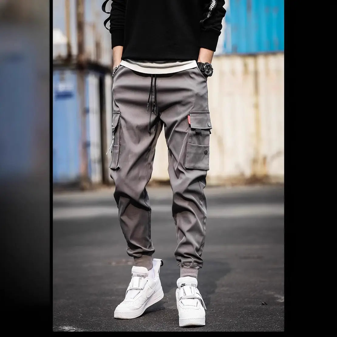 Men tactical cargo pants multi pocket joggers in gray featuring multiple pockets and a drawstring waistband.