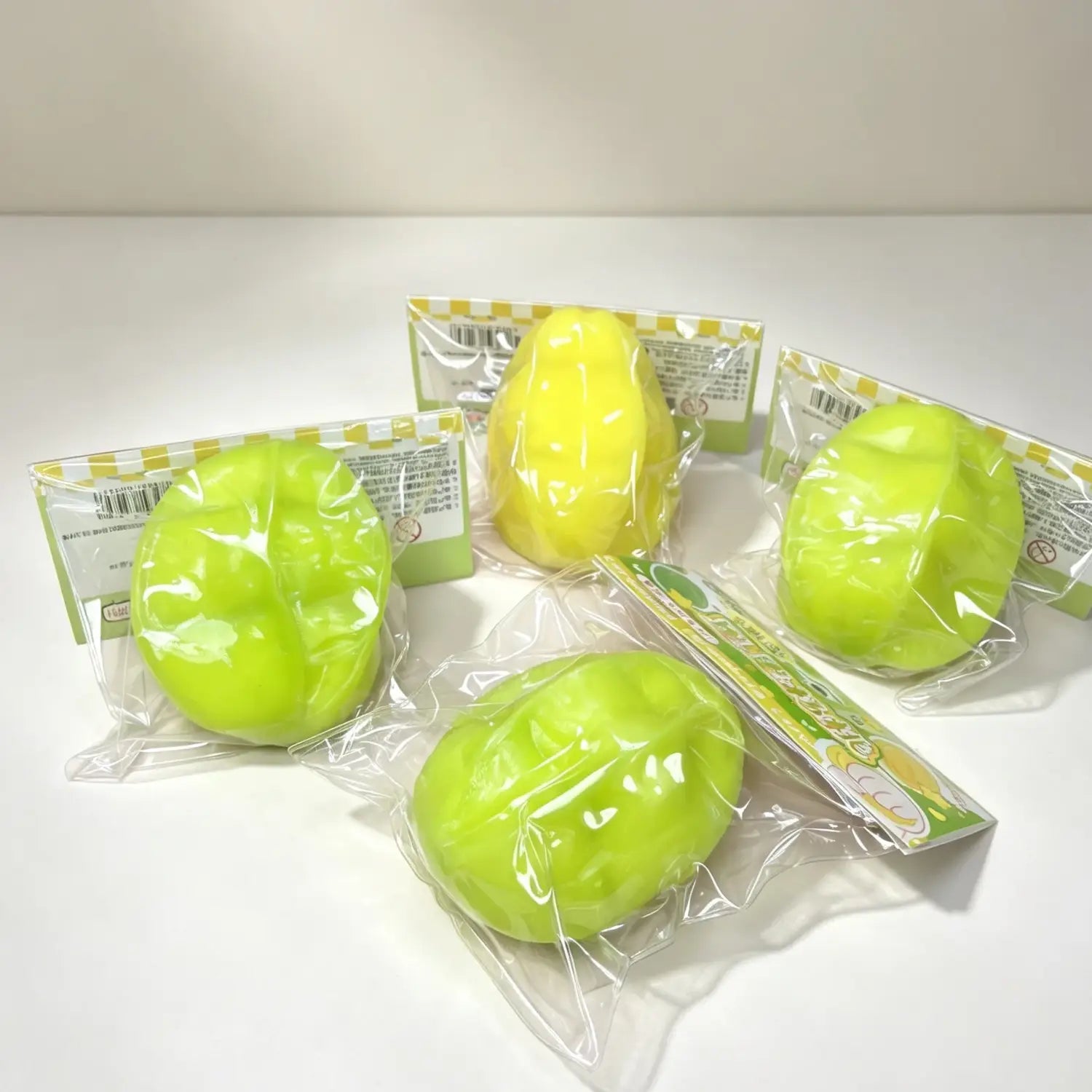 Juguetes blandos de fruta estrella que cambia de temperatura, color verde lima y amarillo brillante, en forma de huevos; pelotas antiestrés envueltas individualmente en plástico transparente con impresión.