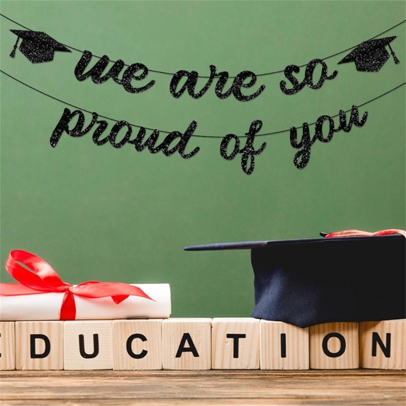 Black glitter graduation cap banner with two mortarboard icons hanging above wooden blocks spelling education and a wrapped diploma tied with red ribbon in a product titled pink glitter graduation proud of you banner.