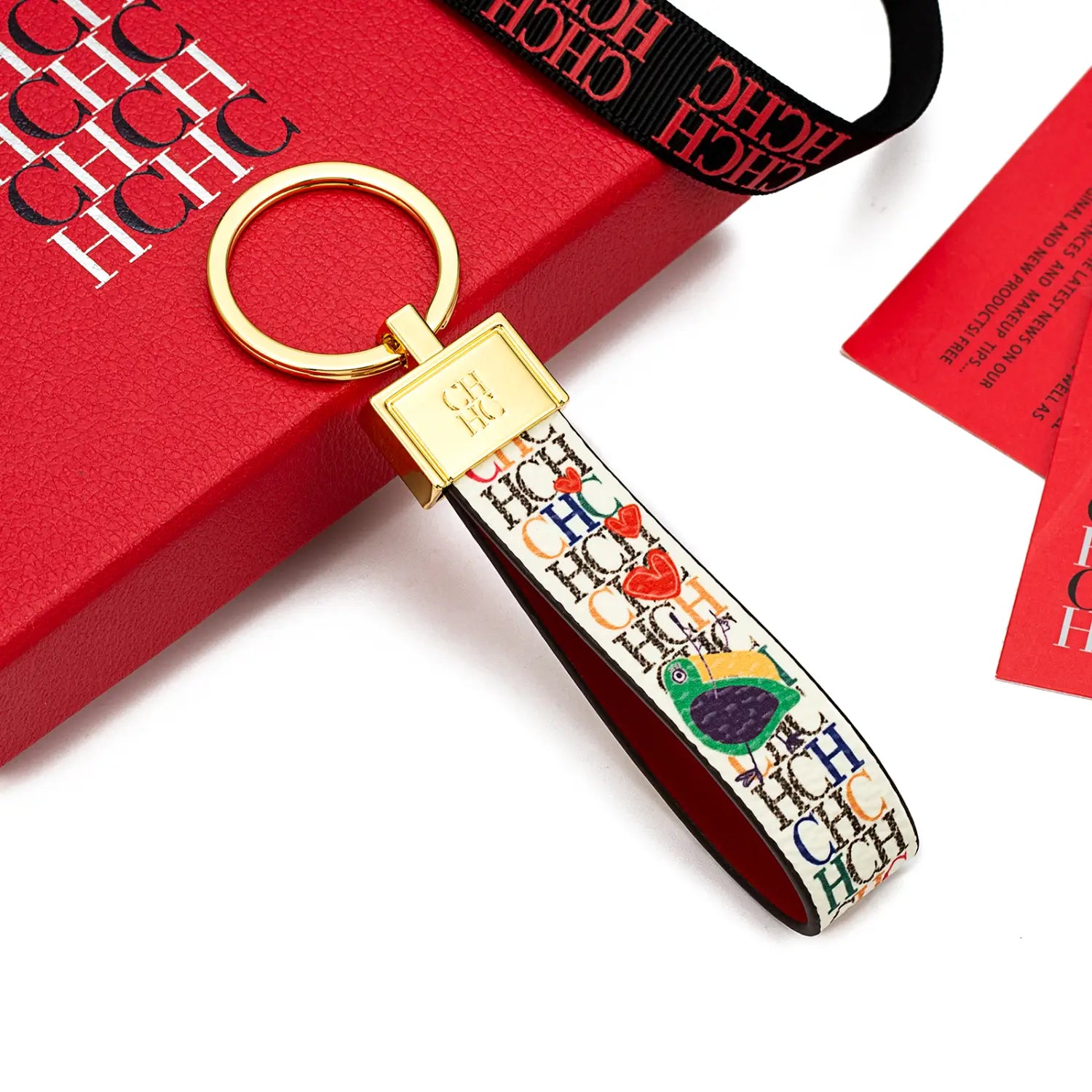 A colorful patterned leather logo keychain with a gold-tone metal ring and rectangular clasp designed as a fashionable accessory and gift.