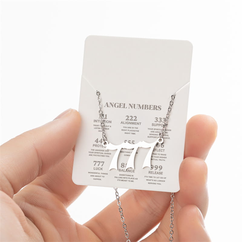 Silver-toned necklace featuring a bold cut-out 777 pendant with an intricate chain, presented as a gold angel number 7 necklace.