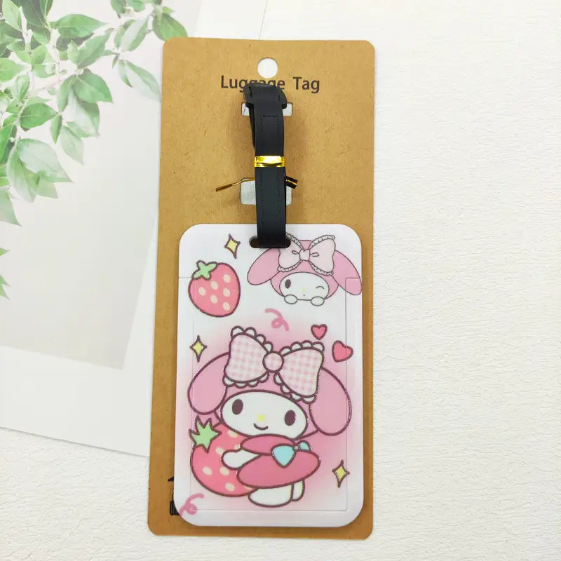 Ensemble d’étiquettes de bagage Hello Kitty comportant une étiquette de valise My Melody rose avec un motif fraise et nœud, fixée à une sangle noire pour l’identification de la valise.