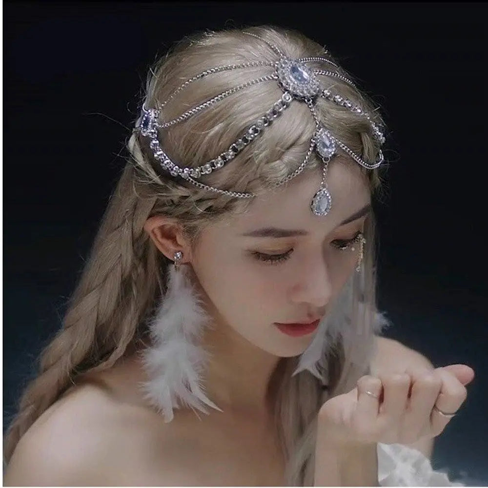 赤い宝石のゴールド前髪チェーンヘアペンダントの商品に用いられた、きらめくラインストーンと揺れる雫型クリスタルをあしらった、繊細なシルバーチェーンヘッドピースです。