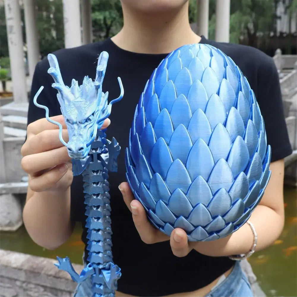 blue 3d-printed giant dragon egg and articulated head figurine set with detailed scales viewed from the front and side.