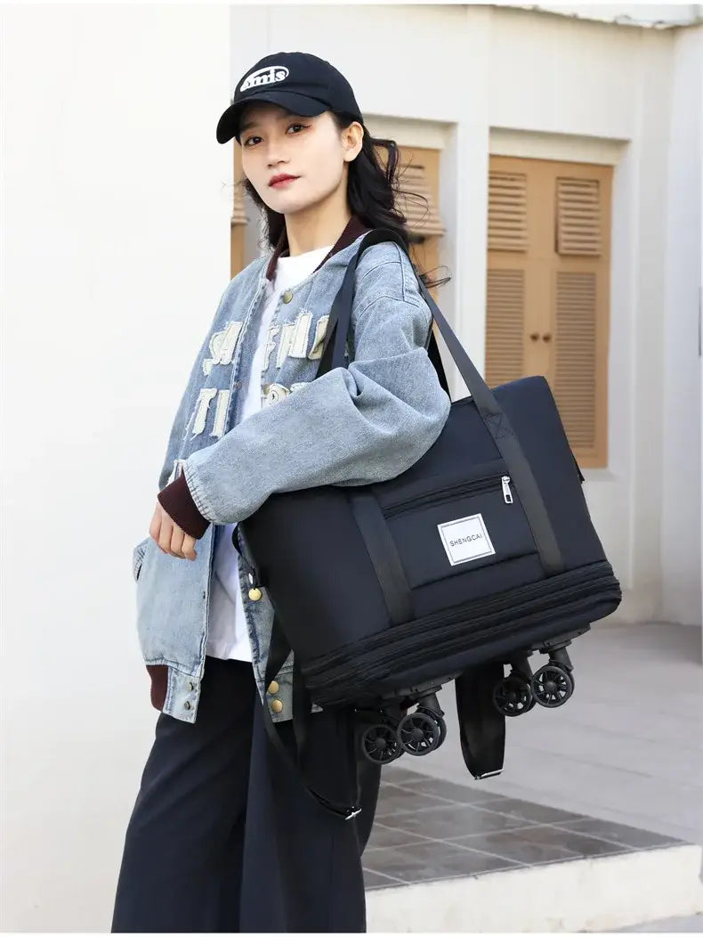 Un sac duffel roulant noir à grande capacité, conçu comme sac à dos de voyage, avec quatre roues et une poche avant à fermeture éclair pour transporter facilement les bagages.