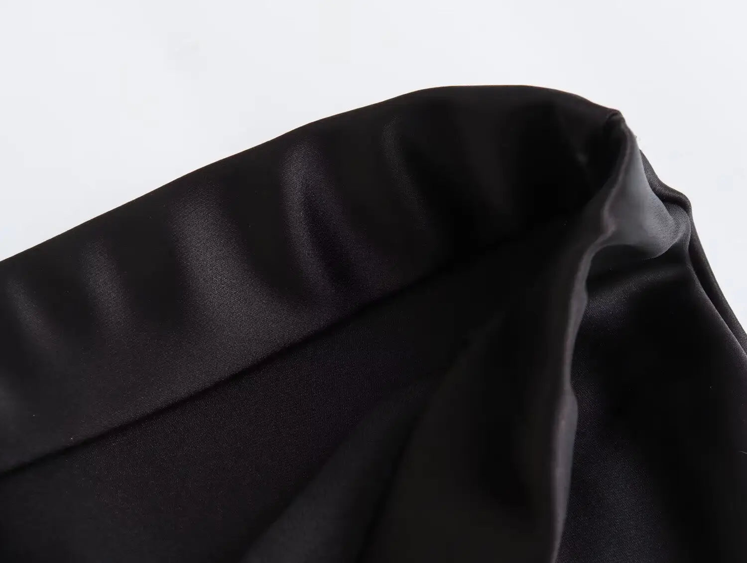 Jupe midi en satin noir à taille haute, finition lisse et brillante, et plis souples dans un tissu luxueux pour une longue jupe élégante.
