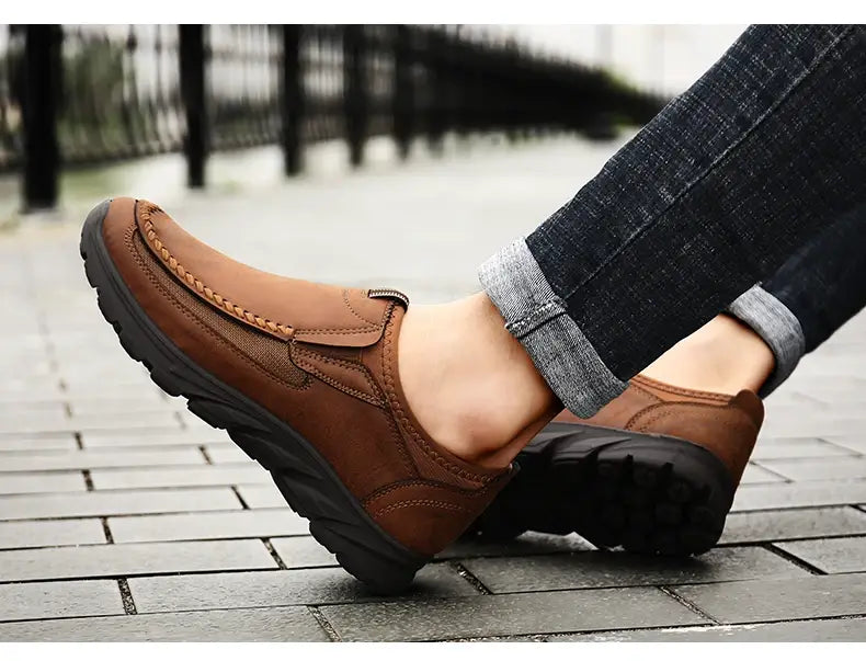 Mocassins homme décontractés en cuir à enfiler en marron, avec des détails cousus et des semelles en caoutchouc noir.