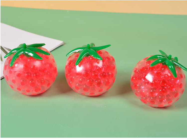 Three red translucent strawberry-shaped gel bead squishy tomato stress relief squeeze balls with green plastic stems.