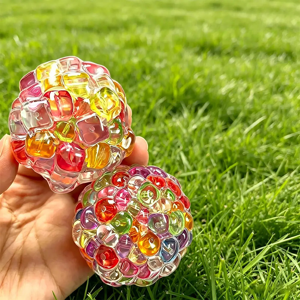 Deux balles de gel à presser pour soulager le stress à base de perles de glace en gel, translucides et colorées, remplies d’une mosaïque éclatante de perles de gel rouges, jaunes, vertes et violettes.