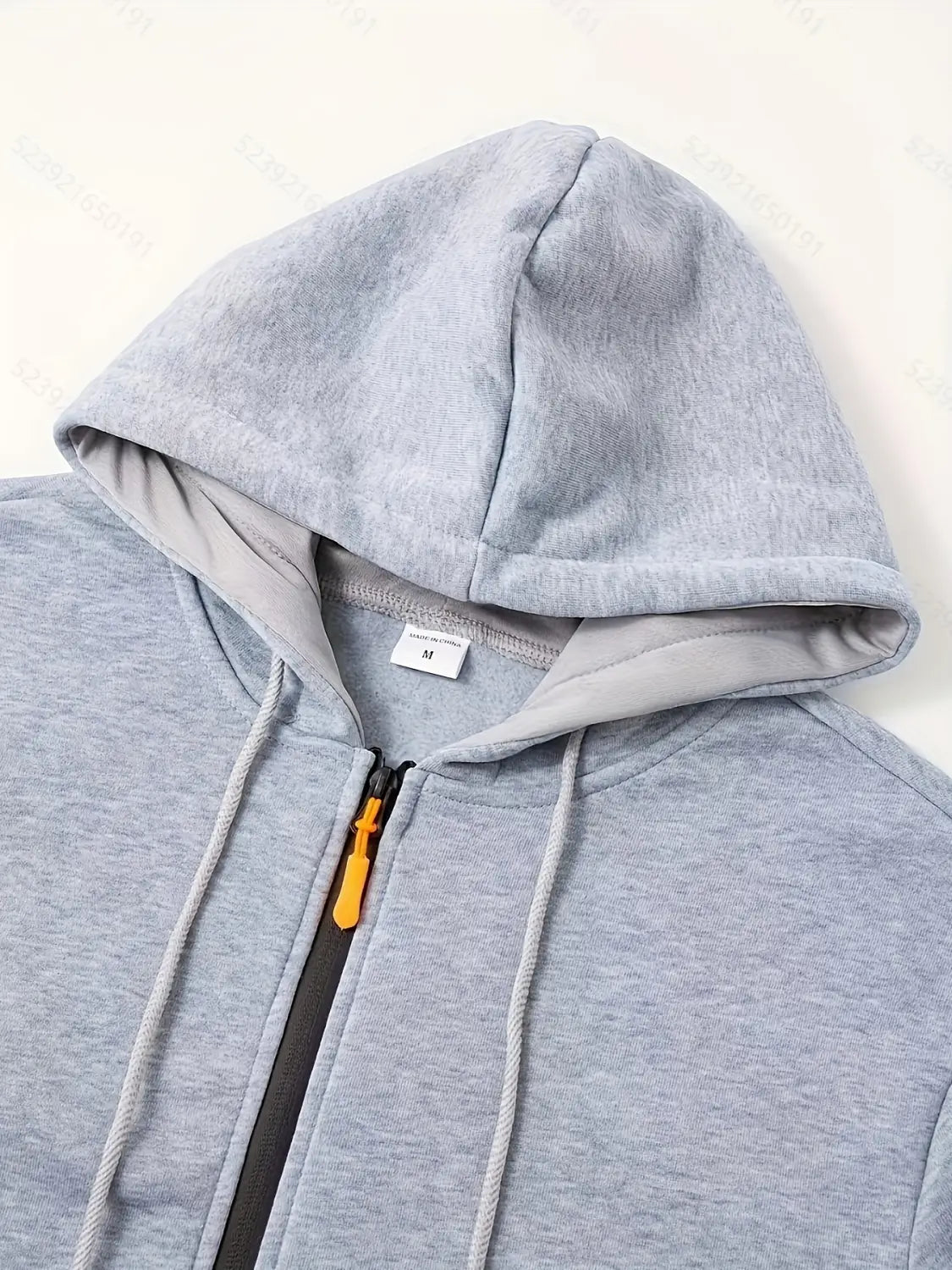 Sudadera tipo zip para hombre casual para otoño e invierno en tela gris jaspeada, con tirador de cremallera naranja contrastante y cordones a juego.