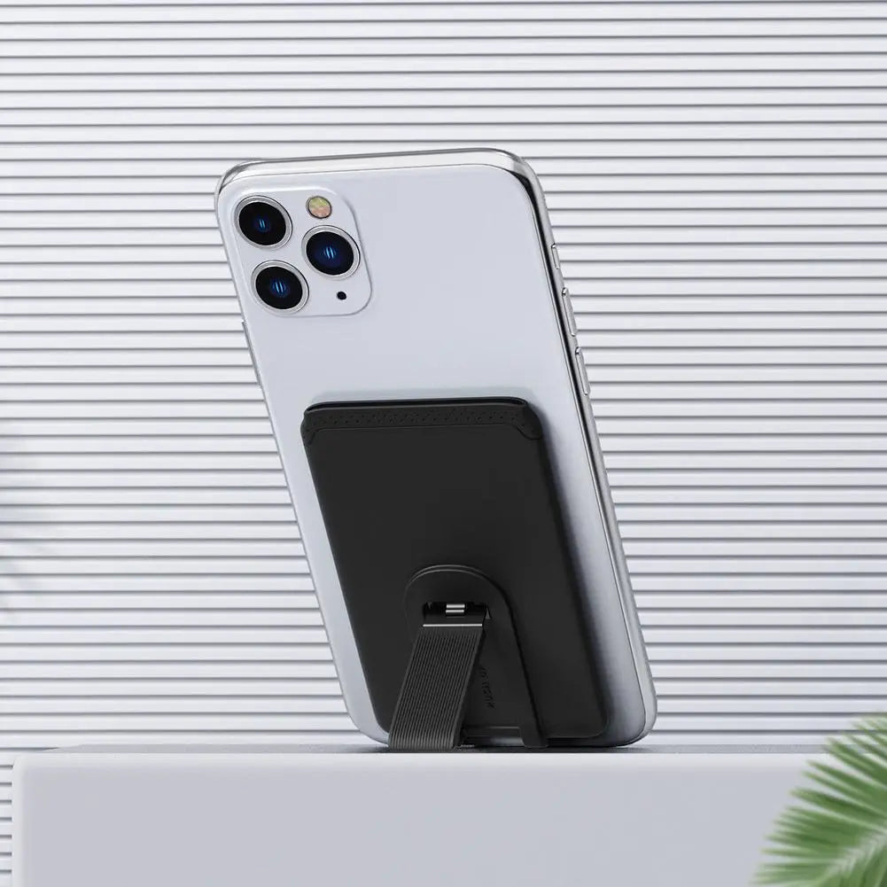 Black magnetic silicone phone card holder with a sleek minimalist design and textured strap securely attached to the back of a silver mobile phone