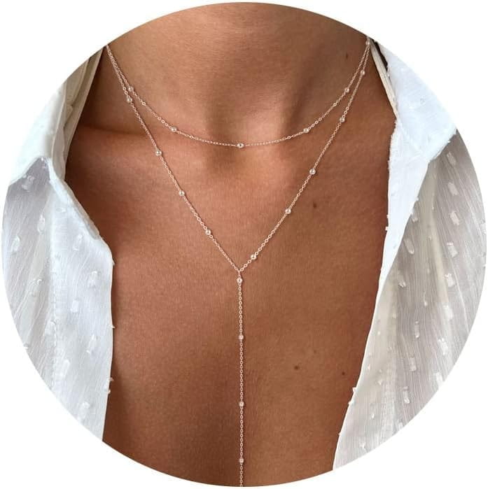 Un collier en « y » en or rosé délicat pour femmes, présentant une chaîne fine avec de petits accents de perles.