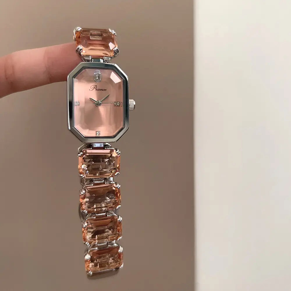 A women quartz crystal watch rose gold rectangular with a delicate pink-toned octagonal face, a bracelet made of faceted peach-colored gemstones, and silver-tone metal accents.