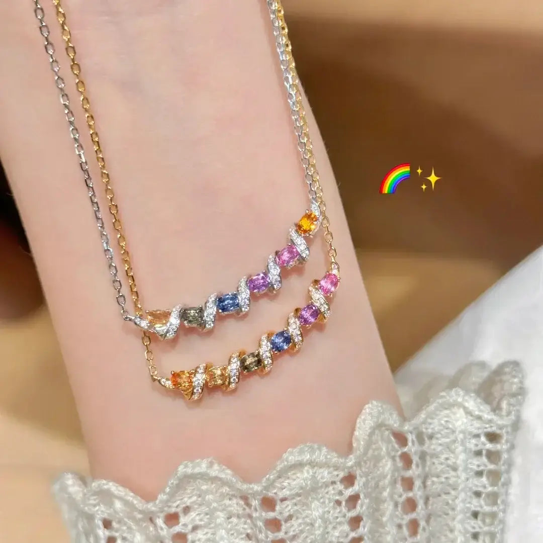 Deux délicats pendentifs de collier à barreaux en argent entrelacés, présentant des pierres précieuses multicolores de type arc-en-ciel avec une finition scintillante.