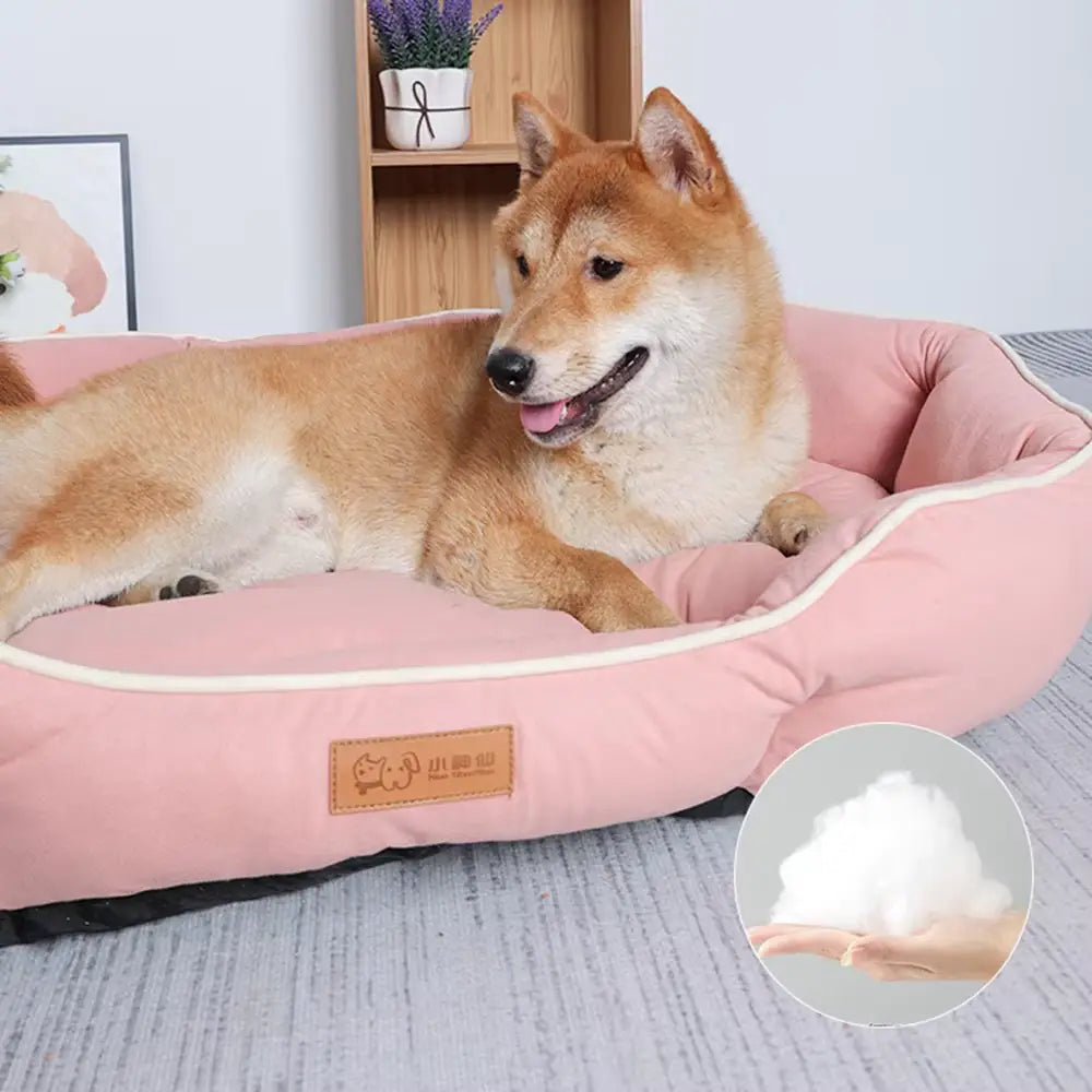 Large pink plush sofa sleeping bed for dogs featuring cream-colored trim and a soft, fluffy interior lining.