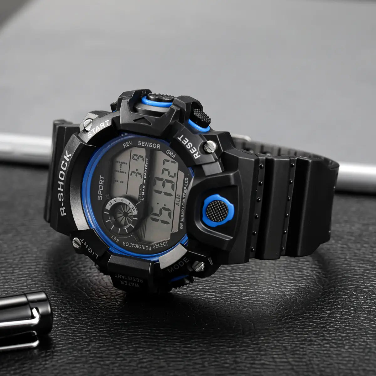 Schwarz-blaue R-Shock wasserdichte digitale Sportuhr für Herren mit robustem, texturiertem Gehäuse und Riemen sowie großem Zifferblatt.