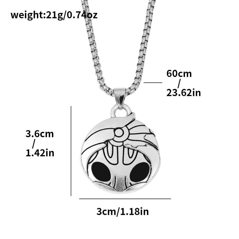 Collier pendentif crâne argenté avec des yeux incrustés noirs et un motif gravé sur une chaîne, issu de la collection de jeux Hollow Knight.