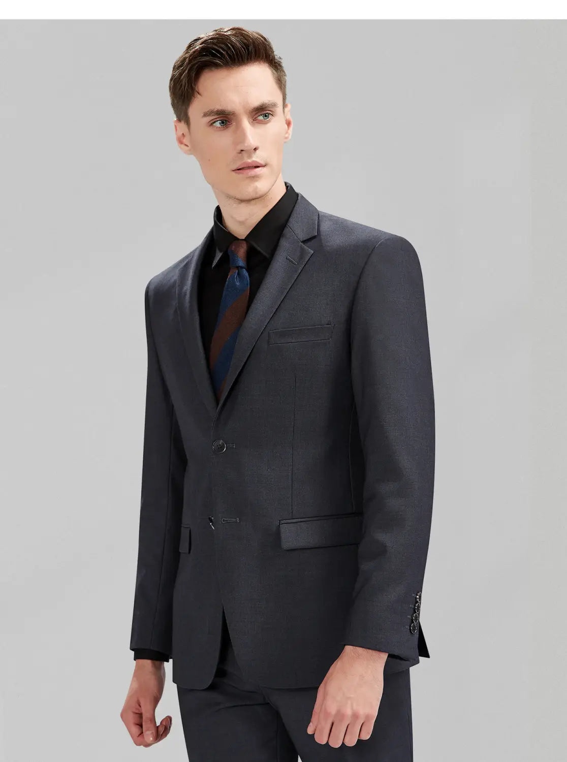 Veste de costume gris foncé pour homme en coupe slim, formelle et professionnelle décontractée, avec texture discrète et épaules structurées, avec un type de fermeture à bouton unique.