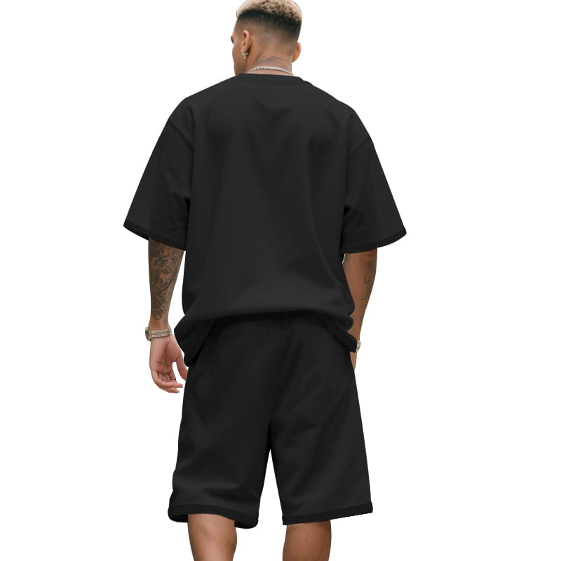 Camiseta oversize negra para hombre con ajuste relajado y mangas cortas, de un conjunto casual de dos piezas, camiseta y pantalones cortos, diseñado para un uso diario cómodo.