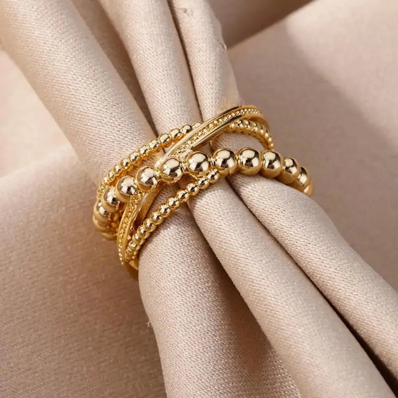 Anillos apilables de acero inoxidable color dorado con cuentas para mujeres, con una combinación de cuentas esféricas lisas y texturizadas, ideales para joyería de boda vintage.