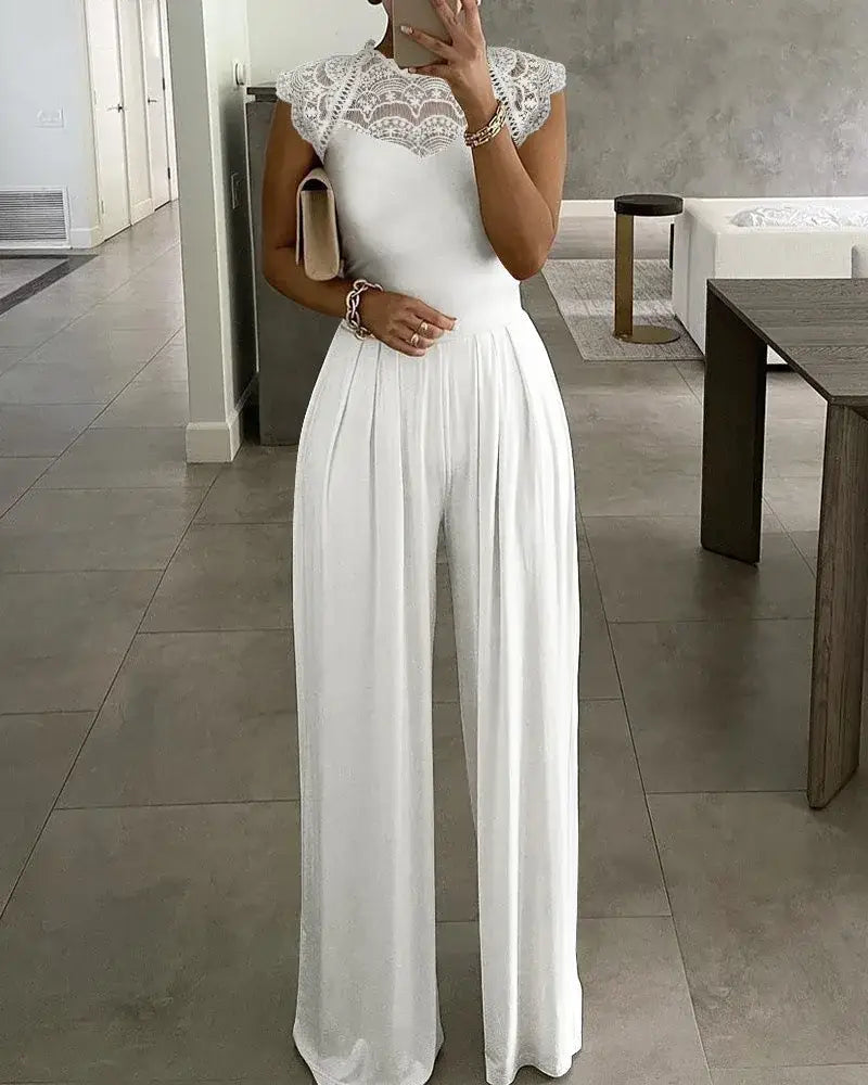 Mono con ribete de encaje blanco que presenta pantalones de pierna ancha con caída y un corpiño ajustado, ideal para ocasiones elegantes