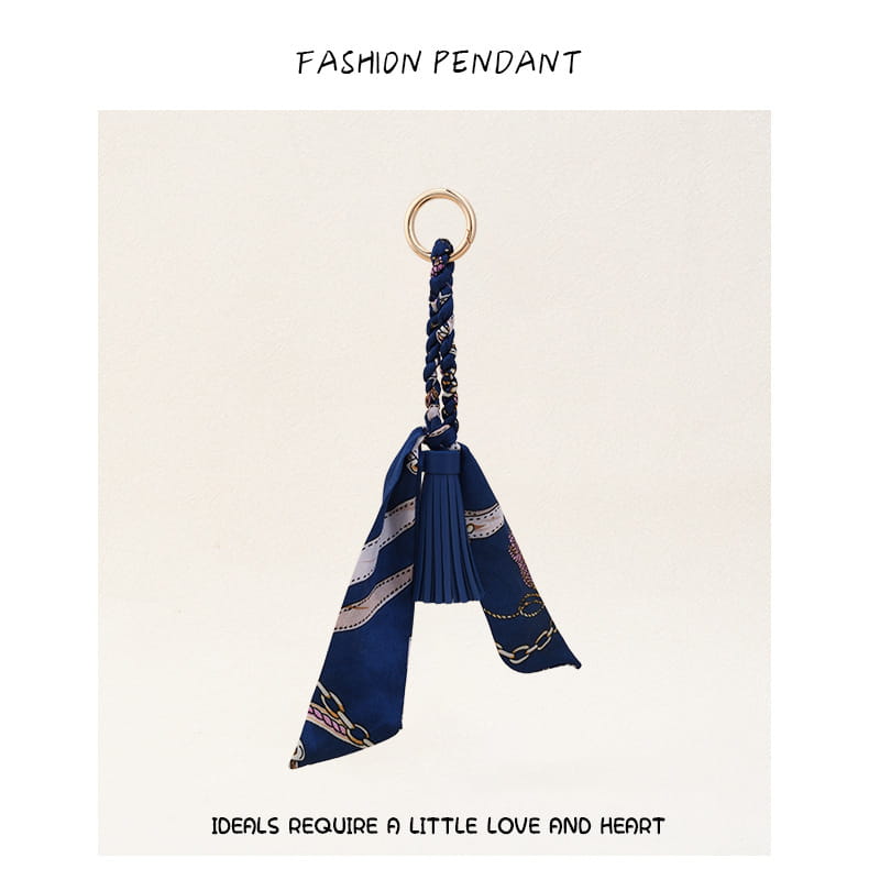 Porte-clés à gland de foulard en soie bleu marine pour sacs, avec un anneau à finition dorée et un cordon tressé présentant un motif de chaîne élégant.