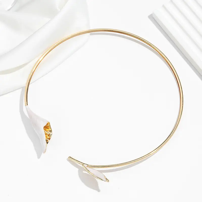 Chokerkette mit goldfarbenem Ton, florales Design mit einer zarten weißen Calla-Lilie sowie Blattakzent im Stil einer Perlenblüten-Kragenkette.