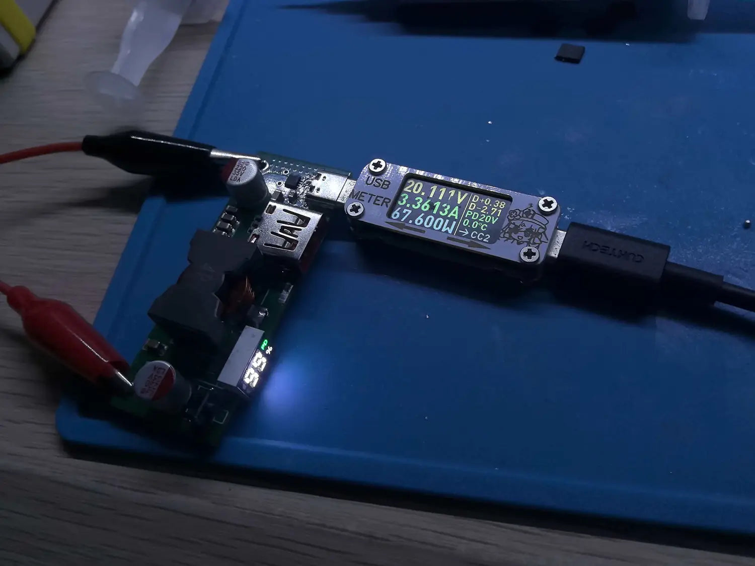 Black usb power delivery meter with green digital display showing voltage current and temperature readings for 100w pd3.1 fast charger power bank module bms.