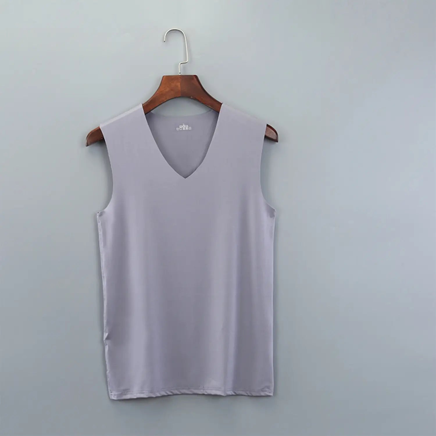 A soft lavender men ice silk sleeveless tank top with a v-neckline hanging on a wooden hanger.