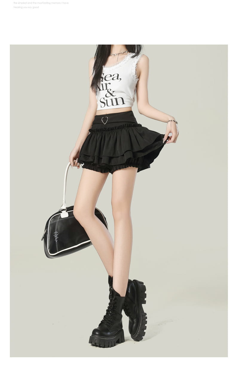Black Y2k ruffled high waist mini skirt with elastic waistband and heart-shaped metal buckle detail.