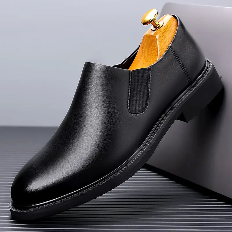 Chaussure habillée à enfiler pour hommes en cuir noir, avec finition polie et soufflets latéraux élastiques pour un usage formel.