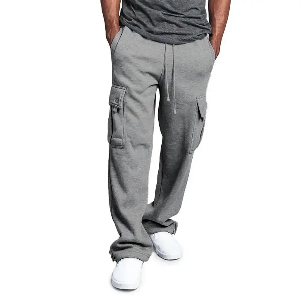 Pantalons de jogging cargo gris pour homme en tissu doux en polaire, dotés de poches latérales et d'une ceinture à cordon de serrage pour une coupe ample de style jogging.