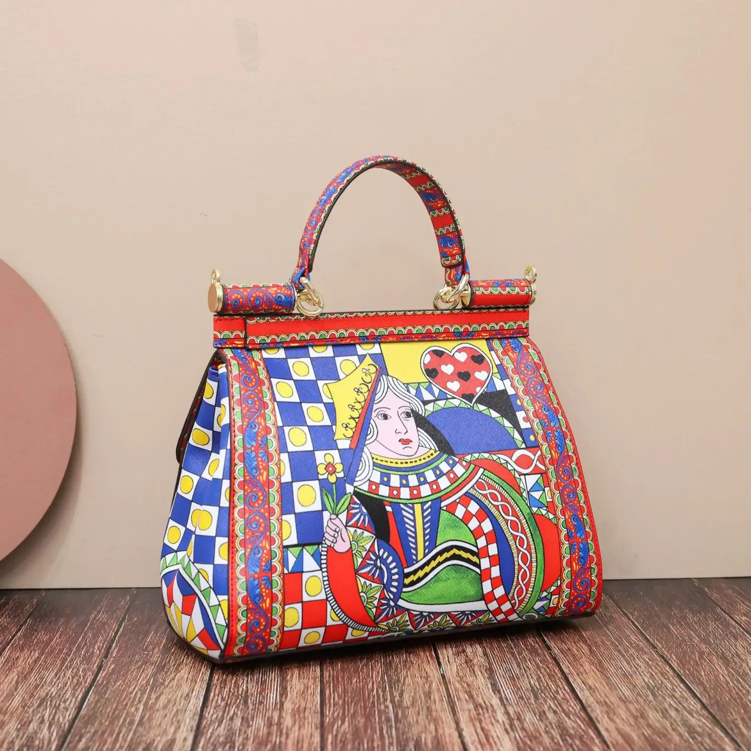 Sac bandoulière en cuir vintage, art raffiné, présentant un motif de carte à jouer de reine, peint à la main et éclatant, avec des accents rouges, bleus et dorés, par Dolce et Gabbana.