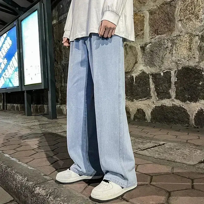Jeans à jambes larges en denim à lavage clair pour hommes, offrant une coupe ample et une silhouette décontractée à jambe droite, idéal pour le streetwear coréen.